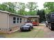 Exterior view of the home showcasing a spacious backyard and covered deck at 208 Holliday Way, Carrollton, GA 30116