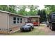 Exterior view of the home showcasing a spacious backyard and covered deck at 208 Holliday Way, Carrollton, GA 30116