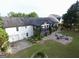 Aerial view of this home shows a sprawling backyard with patio, fire pit, and attached garages at 3550 N Bogan Rd, Buford, GA 30519