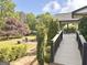 A brick path leads to a firepit surrounded by mature trees and bushes in the backyard at 3550 N Bogan Rd, Buford, GA 30519