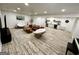 Large open basement with living area, kitchenette, and modern wood-look flooring at 3550 N Bogan Rd, Buford, GA 30519