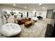 Open basement with living area, kitchenette, piano, and light wood-look flooring at 3550 N Bogan Rd, Buford, GA 30519