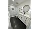 Modern bathroom with glass shower, hexagon tile flooring, and round black framed mirror at 3550 N Bogan Rd, Buford, GA 30519