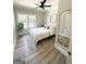 Comfortable bedroom with neutral decor, wood floors, a large window, and a decorative mirror, and a ceiling fan at 3550 N Bogan Rd, Buford, GA 30519