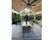 View of covered deck with table, chairs, ceiling fan, and outdoor rug at 3550 N Bogan Rd, Buford, GA 30519