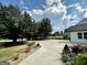 Wide driveway surrounded by lush landscaping and mature trees leads to a charming home with ample parking at 3550 N Bogan Rd, Buford, GA 30519