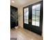 Stylish foyer features black french doors, wood-look flooring, and a decorative tree, creating a welcoming entrance at 3550 N Bogan Rd, Buford, GA 30519
