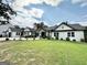 Beautiful two-story farmhouse with a lush green lawn and manicured landscaping on a sunny day at 3550 N Bogan Rd, Buford, GA 30519