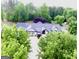 Aerial view of a charming two-story home with lush landscaping and a circular driveway surrounded by trees at 3550 N Bogan Rd, Buford, GA 30519
