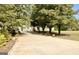Charming two-story home with a long driveway lined with lush greenery and mature trees at 3550 N Bogan Rd, Buford, GA 30519