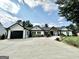Beautiful white home with black trim, complemented by a well-manicured lawn and a spacious concrete driveway at 3550 N Bogan Rd, Buford, GA 30519