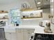 Updated kitchen featuring stylish open shelving, white marble countertops, farmhouse sink, and stainless steel appliances at 3550 N Bogan Rd, Buford, GA 30519