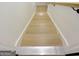 Staircase leading to the basement level with light wood steps and handrail at 3550 N Bogan Rd, Buford, GA 30519