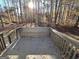 View of back deck with built in seating surrounded by a wooded lot on a sunny day at 473 Amy Blvd, Temple, GA 30179