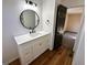 Bathroom features a modern vanity, round mirror, and wood-look flooring at 473 Amy Blvd, Temple, GA 30179