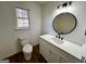 Bathroom with modern vanity, round mirror, and a window providing natural light at 473 Amy Blvd, Temple, GA 30179