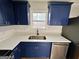 The kitchen features stainless steel appliances, new granite countertops, and sleek blue cabinets at 473 Amy Blvd, Temple, GA 30179