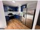 The kitchen features stainless steel appliances, blue cabinets, and new granite countertops at 473 Amy Blvd, Temple, GA 30179
