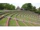 A partially-filled outdoor amphitheater with grass seating and metal railing at 175 Campaign Trl, Fayetteville, GA 30214