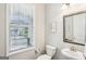 A half bathroom has a pedestal sink, toilet, mirror, light fixture and window with blinds at 175 Campaign Trl, Fayetteville, GA 30214