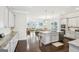 Open-concept kitchen with an island, stainless steel appliances, and hardwood floors that flow into the living area at 175 Campaign Trl, Fayetteville, GA 30214