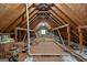 Unfinished attic space with exposed wooden beams and some storage items at 145 Flat Creek Ct, Fayetteville, GA 30214