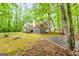 Backyard view of home with a wooden deck and stairs, surrounded by natural foliage at 145 Flat Creek Ct, Fayetteville, GA 30214