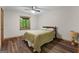 Cozy bedroom features a wood-trimmed window, ceiling fan, and wood-look flooring at 145 Flat Creek Ct, Fayetteville, GA 30214