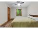Bright bedroom with wood-look floors, ceiling fan, and a view of lush greenery at 145 Flat Creek Ct, Fayetteville, GA 30214