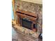 Stone fireplace with an oak mantle and a door that opens to storage at 145 Flat Creek Ct, Fayetteville, GA 30214