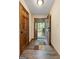 Hallway with wood-look floors leading to an open door with view to the outside at 145 Flat Creek Ct, Fayetteville, GA 30214