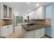 Bright kitchen featuring granite countertops, white cabinetry, and views of wooded backyard at 145 Flat Creek Ct, Fayetteville, GA 30214