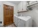 Practical laundry room with a modern washer, dryer, and white overhead cabinets at 145 Flat Creek Ct, Fayetteville, GA 30214