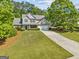 Aerial view of home, landscaping, driveway, and garage surrounded by trees and green grass at 3129 Oak Ridge Ln, Loganville, GA 30052