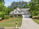 Inviting home exterior with lush green lawn, mature trees, and a well-maintained driveway at 3129 Oak Ridge Ln, Loganville, GA 30052