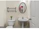 Charming half-bathroom with pedestal sink, toilet, and a decorative mirror, all in a neutral palette at 3129 Oak Ridge Ln, Loganville, GA 30052
