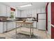 Well-lit kitchen with white cabinets, neutral countertops, and central wooden island at 3129 Oak Ridge Ln, Loganville, GA 30052