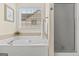 Relaxing soaking tub in the main bathroom with a window view and separate shower at 3129 Oak Ridge Ln, Loganville, GA 30052