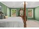 Cozy main bedroom with a four-poster bed, soft green walls, and natural light from two windows at 3129 Oak Ridge Ln, Loganville, GA 30052