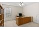 Spacious home office with neutral carpet, a ceiling fan and a large wooden desk at 3129 Oak Ridge Ln, Loganville, GA 30052