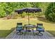 Outdoor patio with seating featuring a table with an umbrella on a concrete patio and lush greenery at 3129 Oak Ridge Ln, Loganville, GA 30052