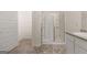 Well-lit bathroom with a glass-enclosed shower, wood-look tile floors, and white cabinets, creating a spa-like atmosphere at 146 Oakchase Park Lane, Hampton, GA 30228
