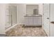 Well-appointed bathroom featuring a double vanity, framed mirror, walk-in shower, and tile floors with a wood-look pattern at 146 Oakchase Park Lane, Hampton, GA 30228