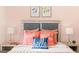 Cozy bedroom with stylish headboard, patterned pillows, bedside lamps, and framed floral artwork at 146 Oakchase Park Lane, Hampton, GA 30228