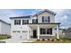 Charming two-story home with white siding, black shutters, and a two-car garage showcasing modern curb appeal at 146 Oakchase Park Lane, Hampton, GA 30228
