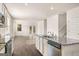 Open-concept kitchen with granite countertops and stainless steel appliances seamlessly connecting to the adjacent living area at 146 Oakchase Park Lane, Hampton, GA 30228