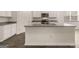 Kitchen island features granite countertops, stainless steel sink, and modern fixtures, creating a stylish and functional workspace at 146 Oakchase Park Lane, Hampton, GA 30228