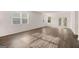 Bright living room showcasing wood floors, natural light from multiple windows, and a patio door at 146 Oakchase Park Lane, Hampton, GA 30228
