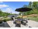 Outdoor patio space with dining table, seating, umbrella, grill and landscape views at 2124 Gaddis Rd, Canton, GA 30115