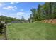 Large backyard with grass lawn, landscaping, and wooded area at 2124 Gaddis Rd, Canton, GA 30115